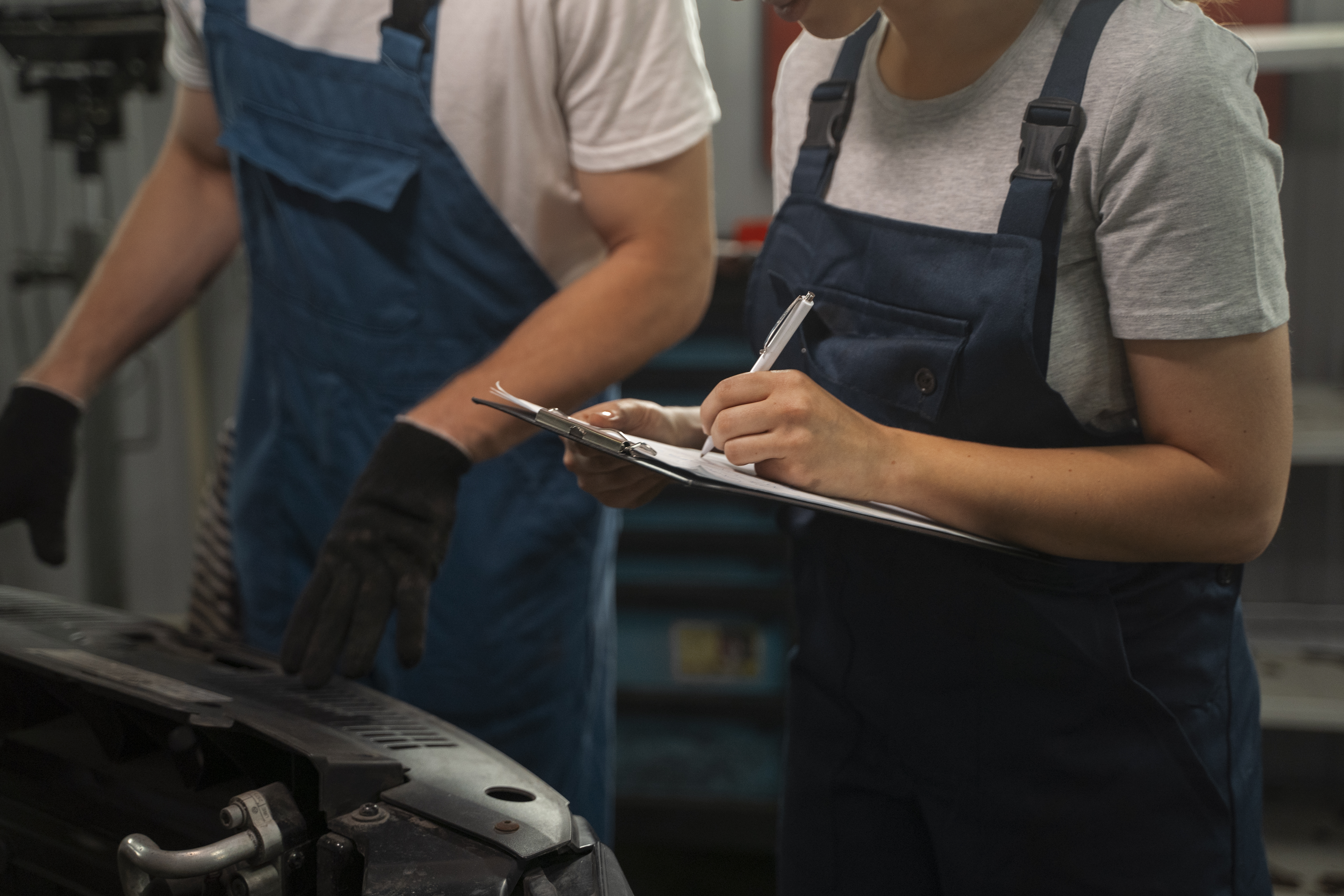 male-female-mechanics-working-shop-car